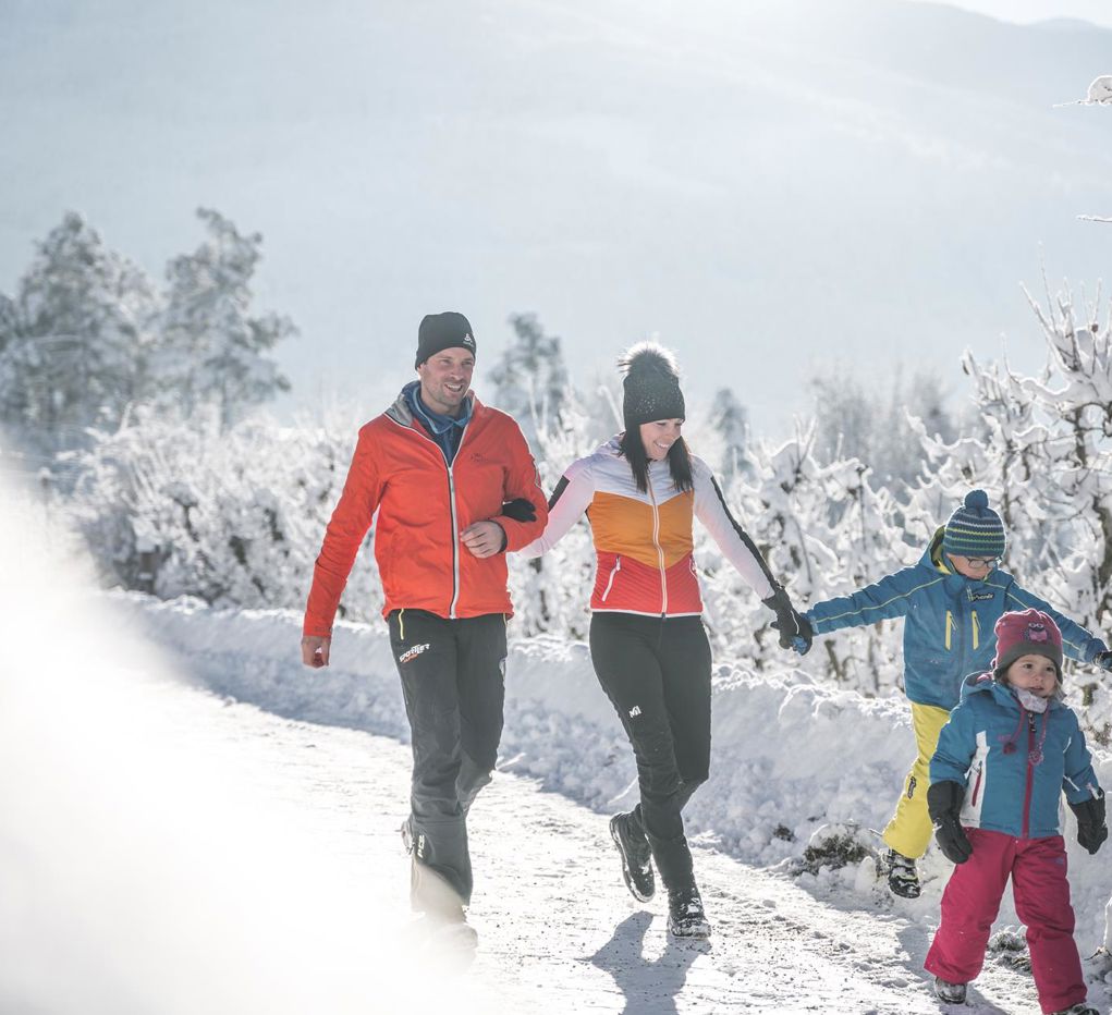 A family is hiking in the snow